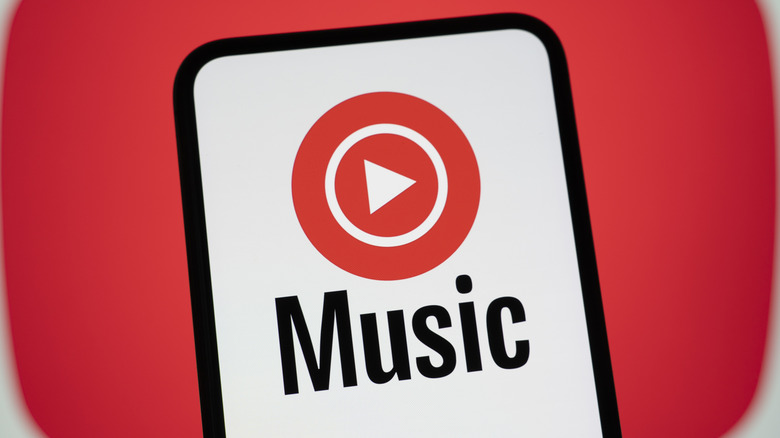 A phone showing the YouTube Music logo with the word Music written underneath