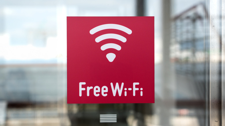 a red free wi-fi signboard on a glass surface