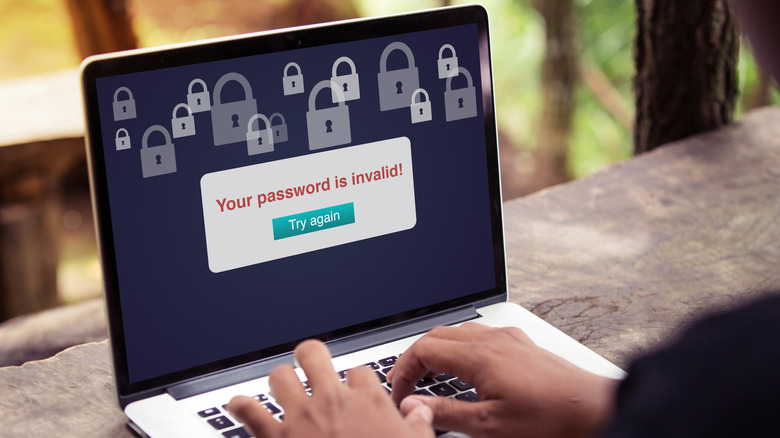 person working on a laptop with the screen reading Your password is invalid, try again