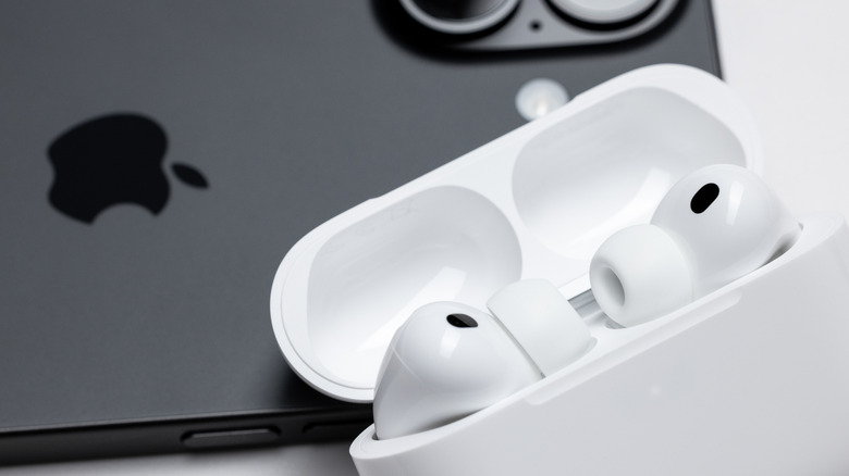 Apple AirPods pro 3 with the case open placed on an iPhone 17