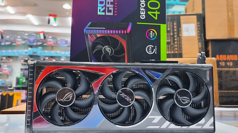 ASUS ROG Strix graphics card with three cooling fans displayed in a store.
