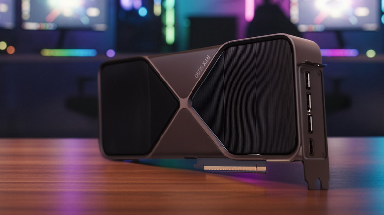 NVIDIA GeForce RTX 5090 graphics card on a desk with RGB lighting in the background.