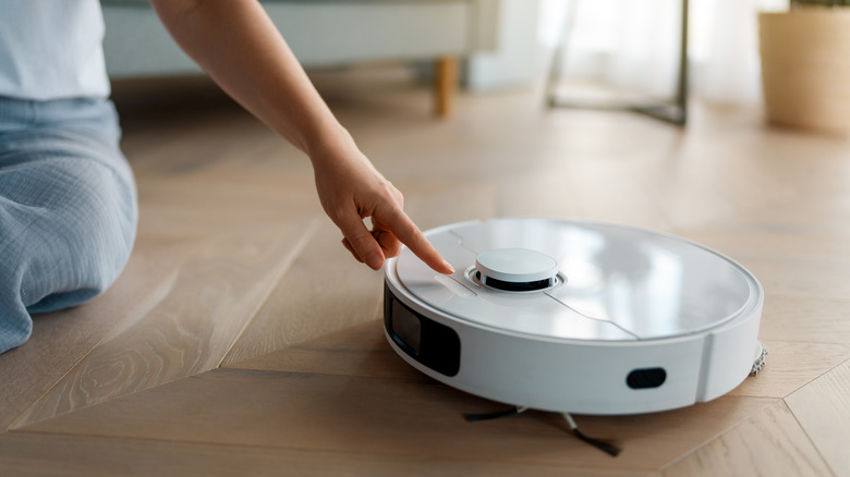 A person operating a robot vacuum.