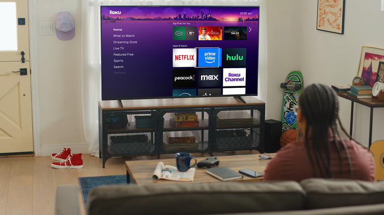 Man in the living room choosing a channel on Roku.