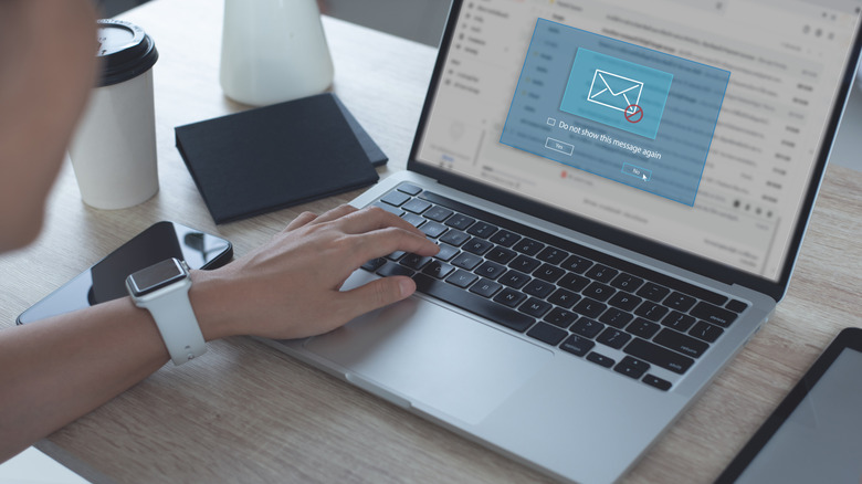 A person blocking spam email on a laptop.