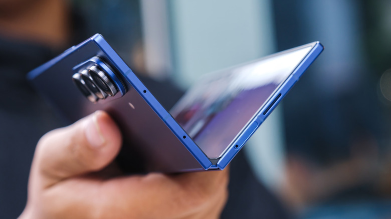 Samsung Galaxy Z Fold partially opened showing hinge and camera module.