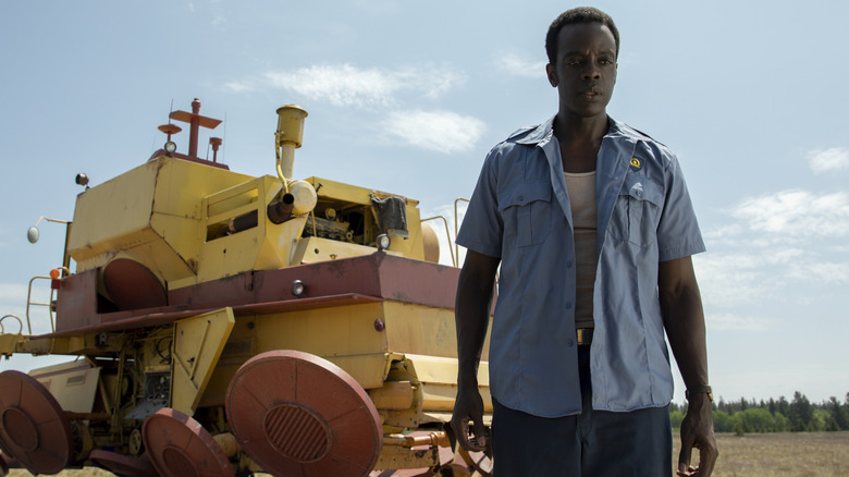Ato Essandoh as Gaddis standing in front of a large machine in Tales from the Loop.