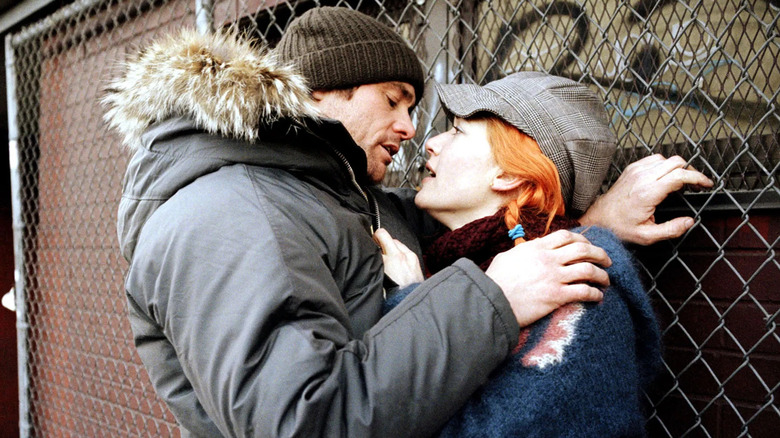 Joel and Clementine about to kis in front of a wire fence