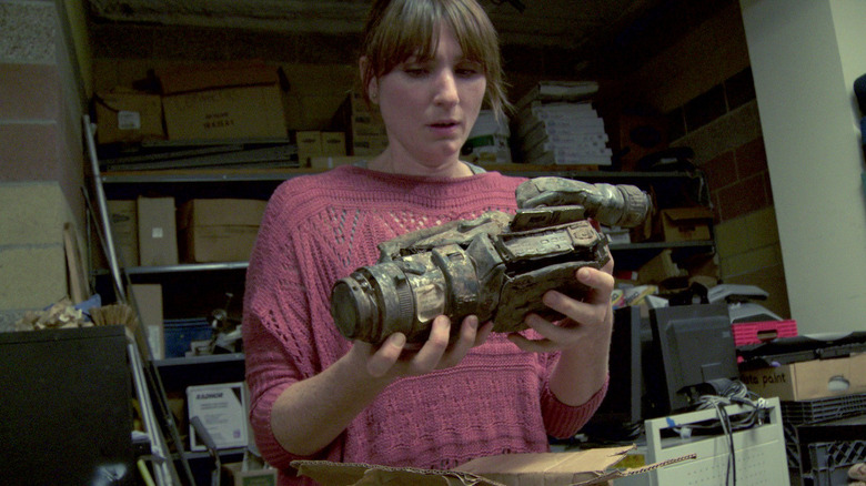 Sophie holding a dirt-crusted camera in "Phoenix Forgotten."