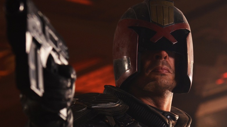 Dredd (Karl Urban) aiming his gun in Dredd