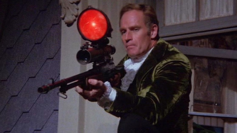 Charlton Heston as Robert Neville holding a rifle in The Omega Man