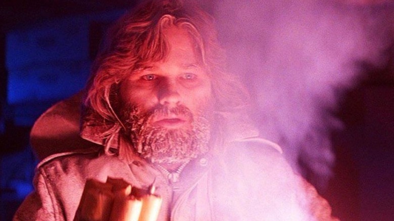 Kurt Russell as MacReady holding a flare in The Thing (1982)