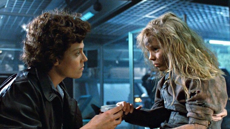 Sigourney Weaver as Lt. Ellen Ripley and Carrie Henn as Newt hold hands in a scene from "Aliens"