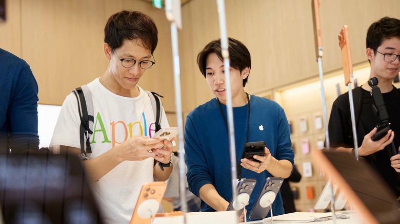 An Apple Store employee helping a customer buy the new iPhone