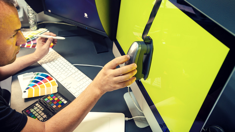 A professional calibrating monitor colors