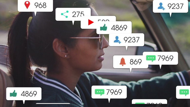 A driving woman covered in notification balloons.