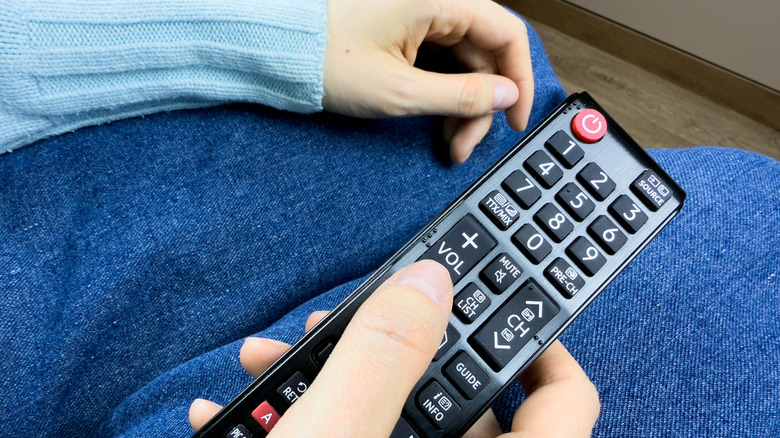 A person using a Samsung TV remote