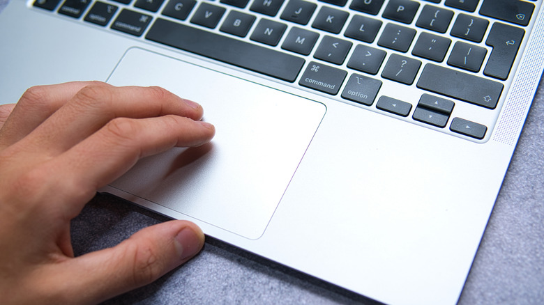 A person using the touchpad on a MacBook