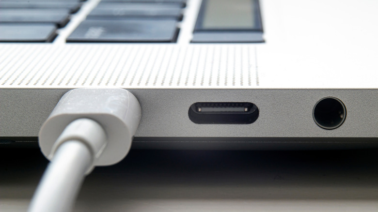 A MacBook laptop plugged in and charging