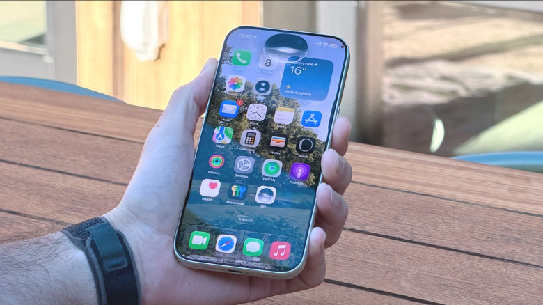 A hand holding an iPhone running the new Siri AI
