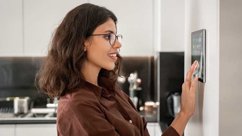A woman interacting with her home's smart hub