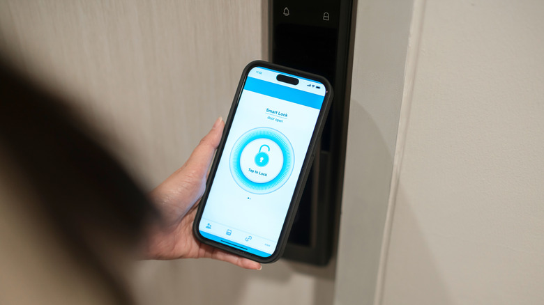 A person using a phone to access a smart lock