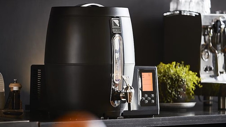 The BrewArt BeerDroid smart home brewer is placed on the counter.