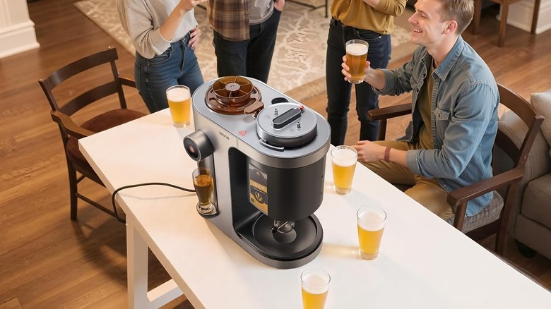 Vevor automatic home beer brewer is seen on a living room table at social gathering.