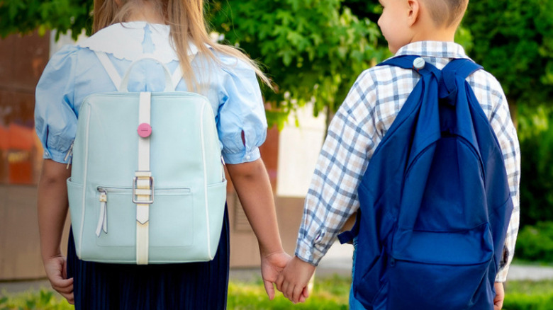 Two children wearing Roam Smart Trackers on their backpacks