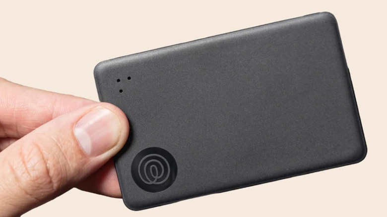 A person holding the Life360 Tile Slim tracker card