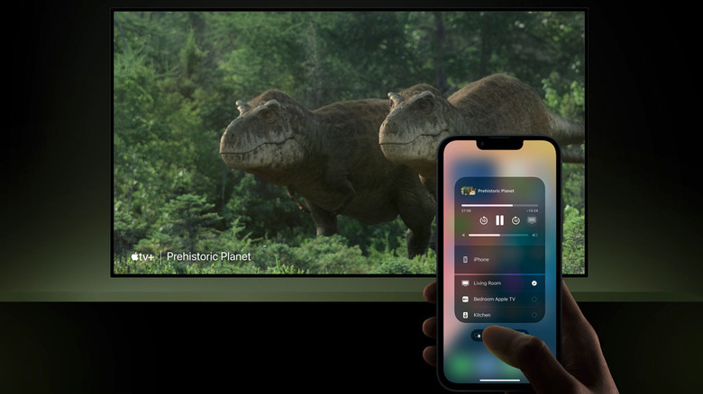 A person using AirPlay on an iPhone to cast video to a TV.