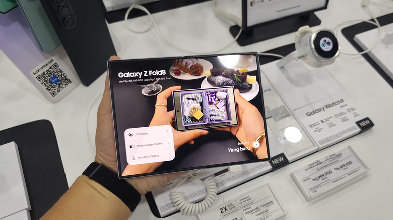 Samsung Galaxy Z Fold8 held open in an electronics store with the inner display visible.