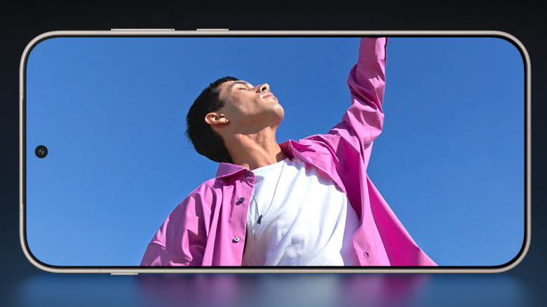 OnePlus 15 showing a person in a pink shirt on its display.
