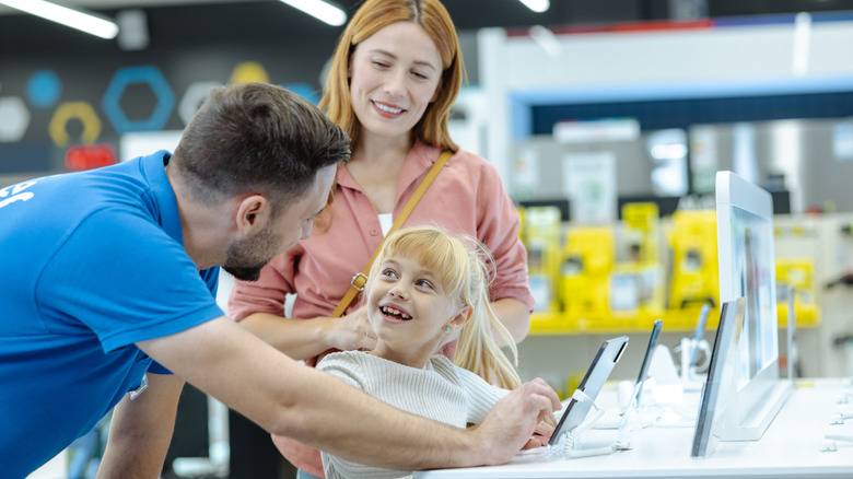 Salesperson helping a family shop for smartphones