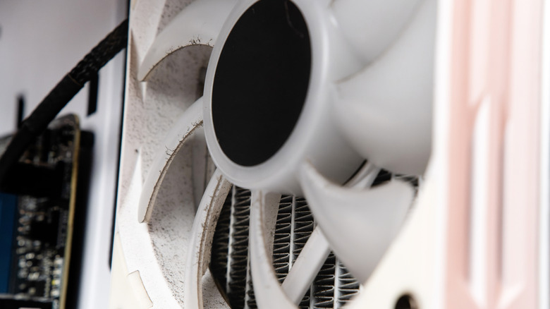 Dusty fan and radiator fins inside a liquid cooling system.
