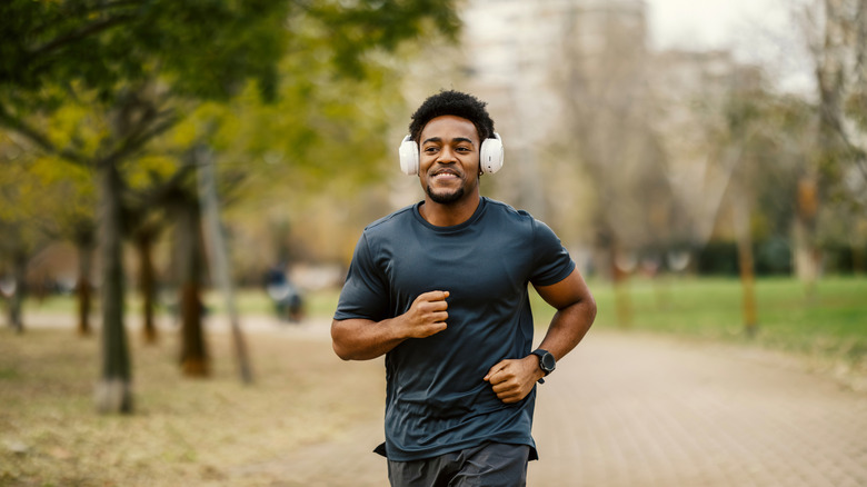 A man jogging with headphones on, listening to music