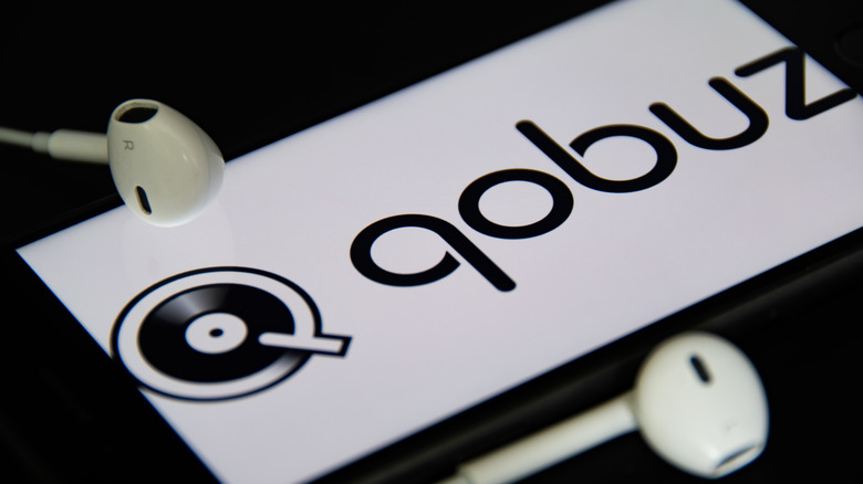 Earphones beside a smartphone with the Qobuz logo displayed