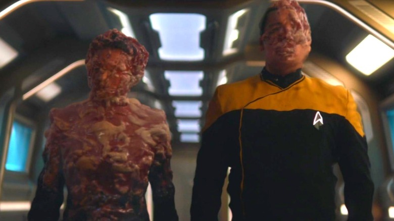 Two changelings mid-transformation, wearing Starfleet uniforms.