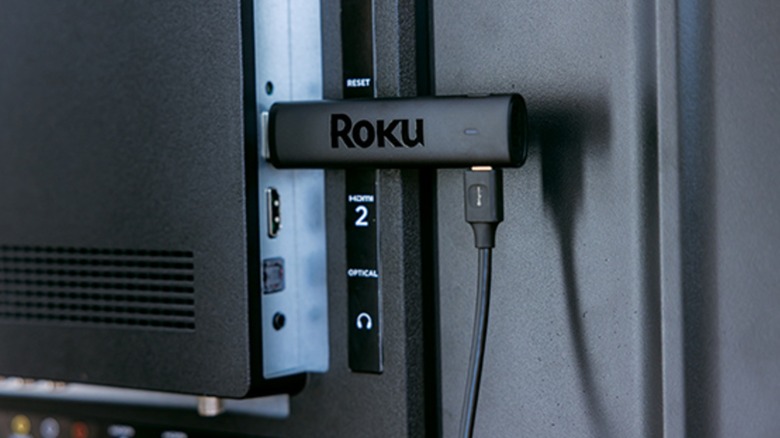 Roku Streaming Stick 4K plugged into HDMI port behind TV