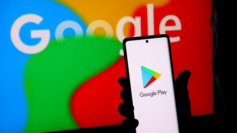 Hand holding phone with Google Play Store logo