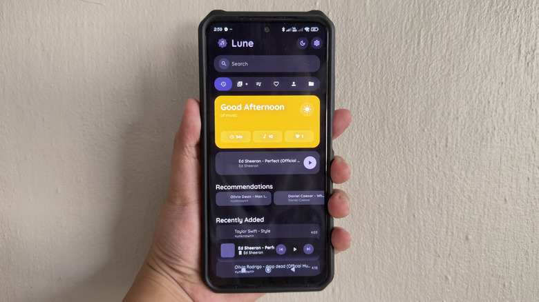 Hand holding Android phone showing Lune app