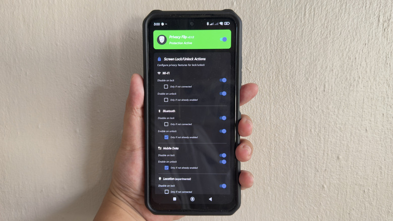 Hand holding Android phone showing PrivacyFlip app