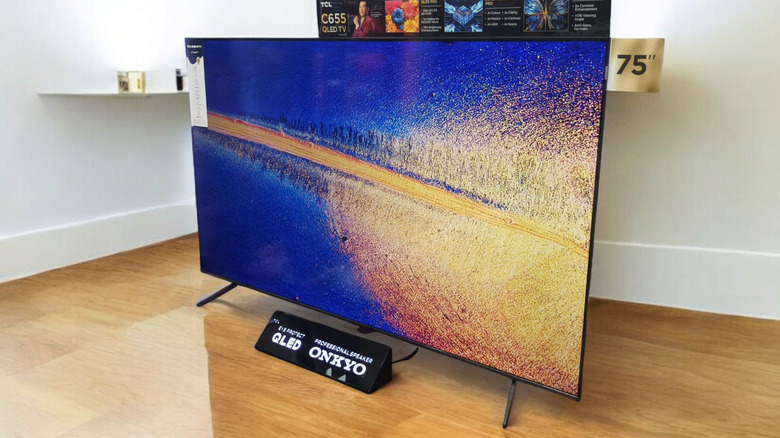 A TCL QLED TV features displays a bright image of blue, orange, and yellow