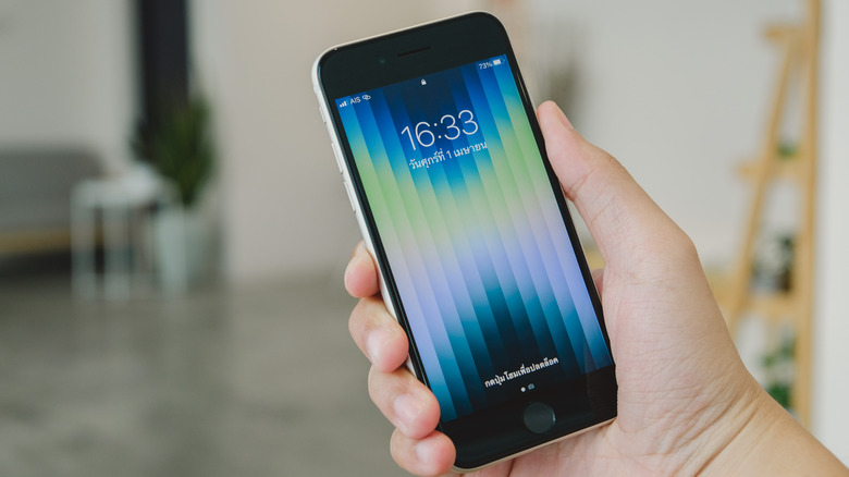 iPhone SE 3 being hold by someone. It was the last iPhone with a Home Button