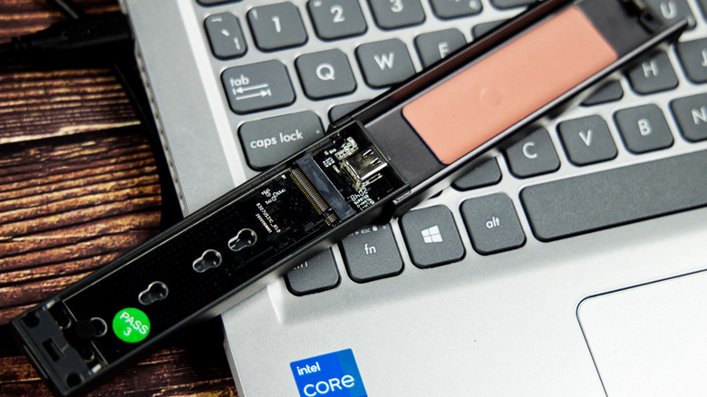 The Sabrent EC-SNVE NVMe SSD enclosure opened on a laptop keyboard.