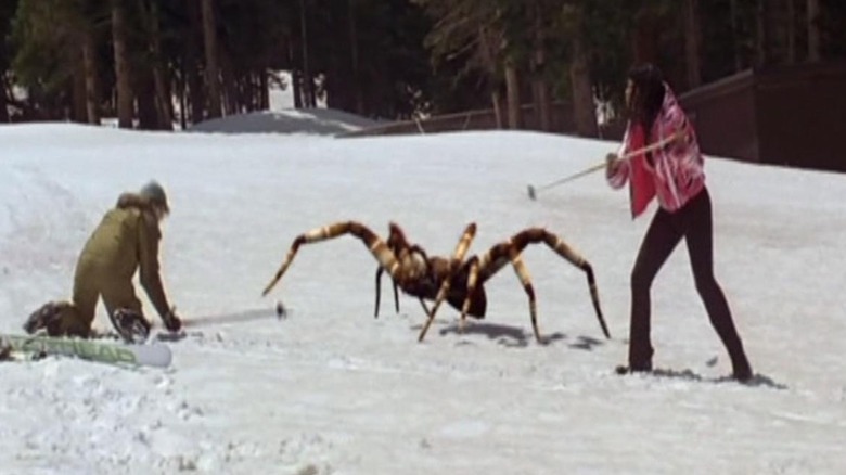 Two people stabbing an oversized spider with skiing poles in "Ice Spiders."