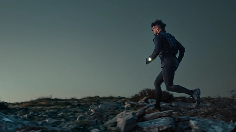 A man running with a Garmin smartwatch with the flashlight on