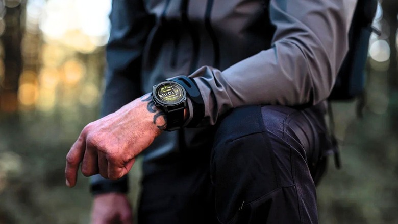 A man's wrist showing a Garmin watch