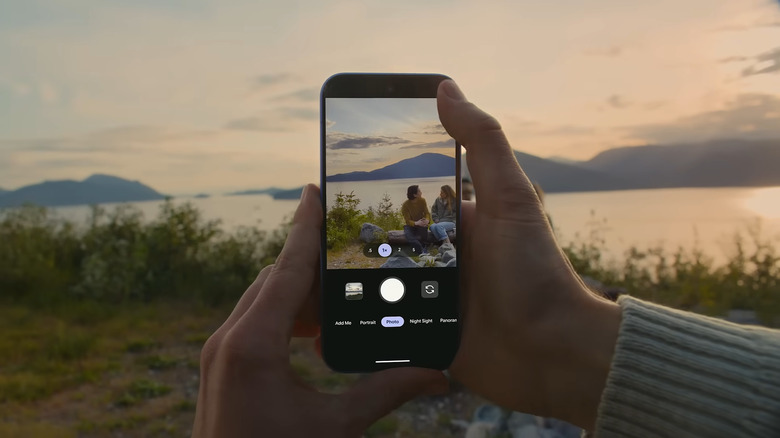 Hand holding Google Pixel 10 while taking a photo of a couple