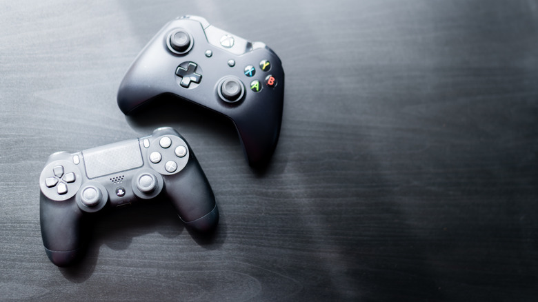 An Xbox One controller next to a PlayStation 4 DualShock on a table